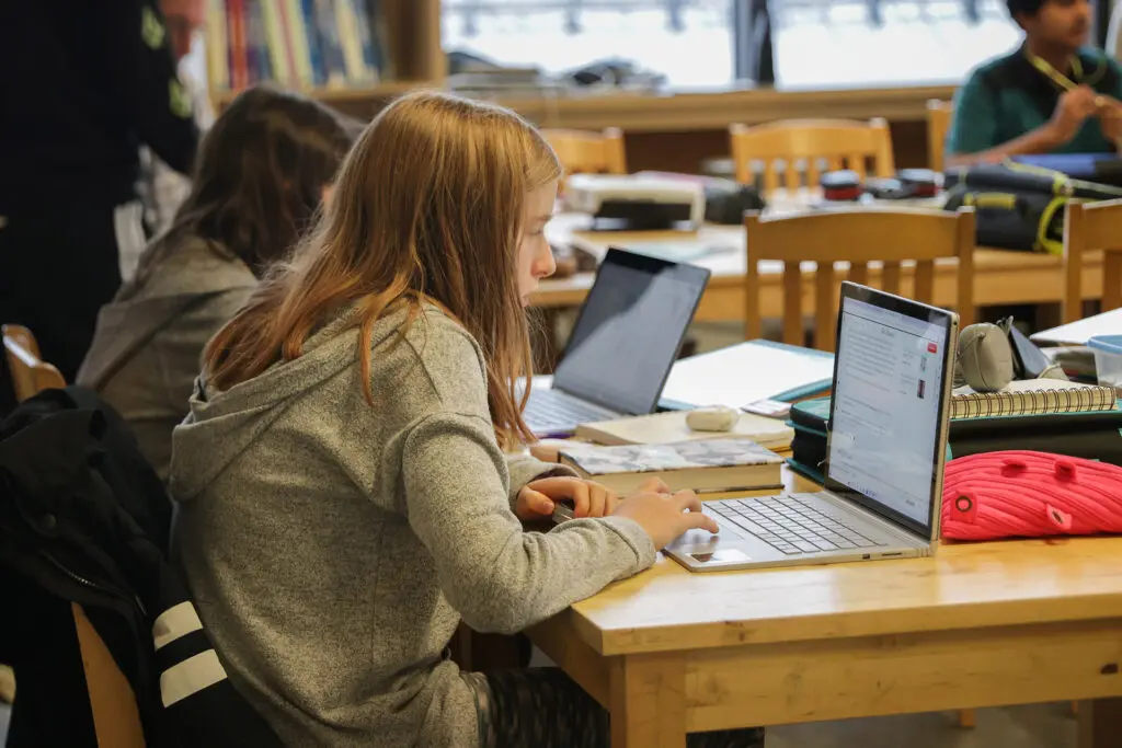 Élève à un bureau en train d’étudier sur un ordinateur portable